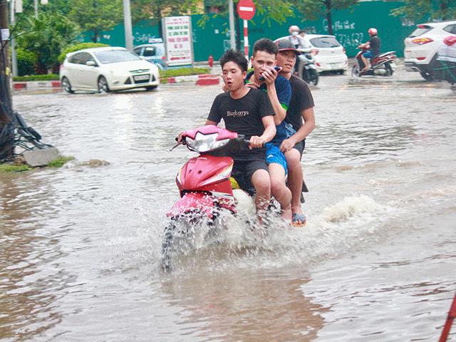 Sau bão số 3, người dân đầu trần, kẹp 3, kẹp 4 vượt phố ngập nước ở Hà Nội