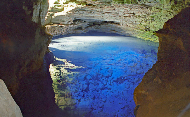 Nằm giữa biên giới phía đông của dãy núi Chapada Diamantina gần Andarai phía Bắc Brazil, Poço Encantado &#40;Giếng Trời&#41; là một hồ nằm sâu trong lòng đất, với một cửa sổ tự nhiên thông với cánh rừng Bahian ở bên trên. Từ tháng 4 đến tháng 9 hàng năm, ánh nắng chiếu xuống khiến ước trong hồ có màu&nbsp;màu xanh biếc huyền bí.