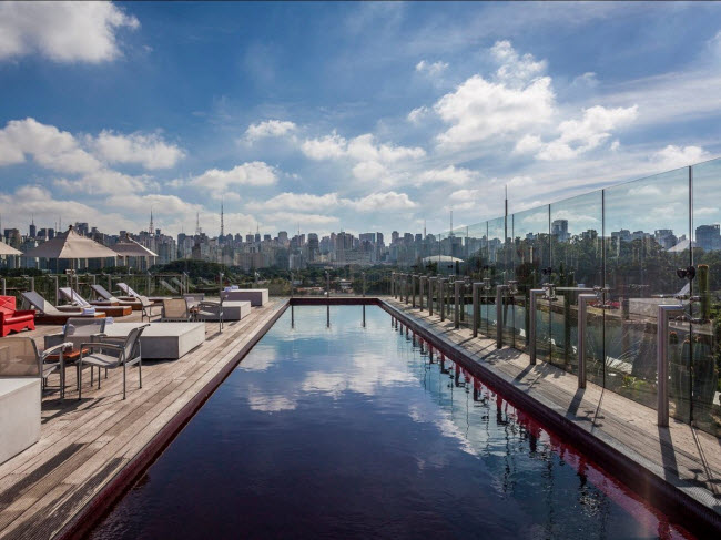 Khi nhìn xuống bể bơi màu đỏ&nbsp;ở giữa quán bar Skye tại thành phố São Paulo ở Brazil, bạn có thể nhìn thấy công viên Ibirapuera và những tòa nhà cao tầng quanh thành phố.