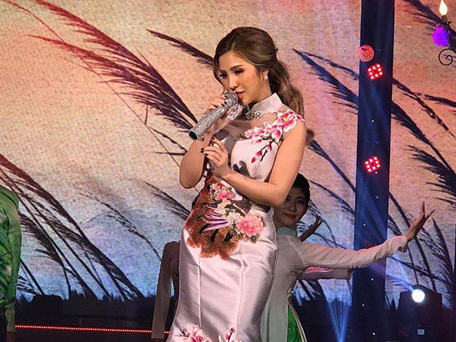 Trên sân khấu trịnh trọng, nữ DJ kiêm ca sĩ diện áo dài truyền thống thướt tha.