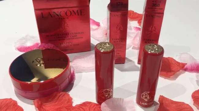 Hãng mỹ phẩm Lancome mở đầu bằng bộ sản phẩm đón xuân, bao gồm một hộp phấn nước và hai thỏi son với màu đỏ chủ đạo. Trên mỗi thỏi son đều có khắc hình chú chó khá lạ mắt và độc đáo