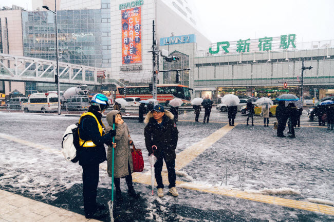Một số người vẫn thoải mái đứng nói chuyện dưới tuyết rơi ở khu Shinjuku, Tokyo.