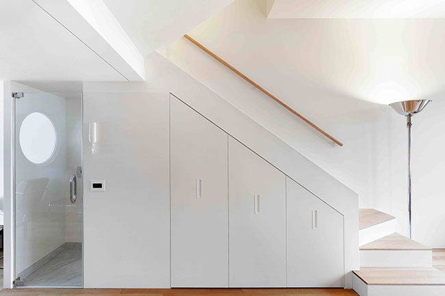 Phần chân cầu thang được tận dụng tối đa thành các tủ và được sơn màu trắng tạo cảm giác rộng rãi.