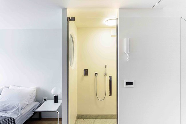 Phòng tắm đơn giản, với lớp cửa kính và hệ thống hút mùi hiện đại.