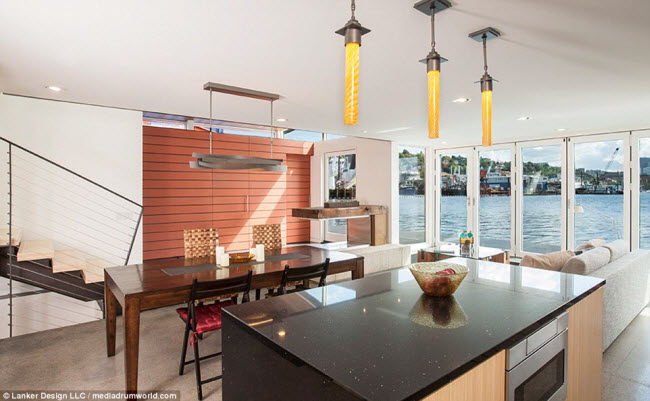 Không gian bếp và phòng khách tràn ngập ánh sáng tự nhiên nhờ những ô cửa sổ kính lớn.