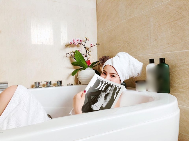 Phạm Hương quấn khăn tắm, nằm trong bồn chụp ảnh tinh nghịch.