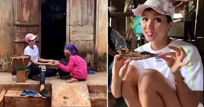 Trong clip phóng sự của bản thân, H&#39;Hen Niê thoải mái ngồi bệt xuống sàn nhà ở quê, thưởng thức món cá khô, cà đắng đạm bạc cùng bà con. Đây vốn là món tủ yêu thích của mỹ nhân sinh năm 1992.