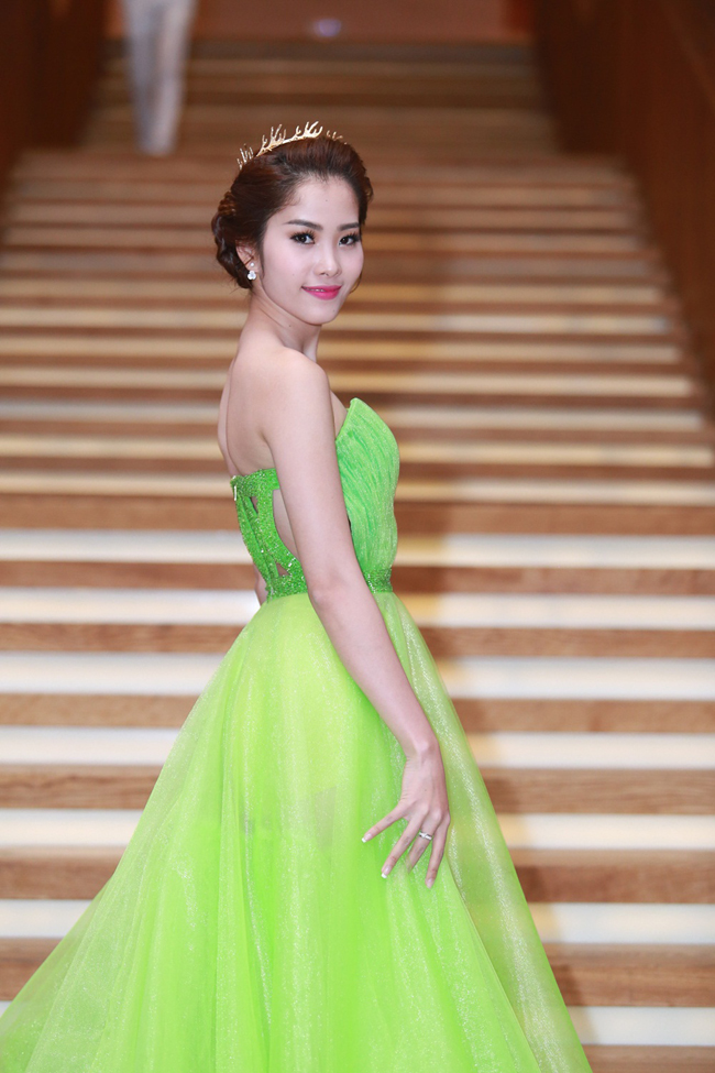 Người mẫu diện chiếc đầm xanh lá kiểu công chúa, tạo dáng ở các góp chụp.
