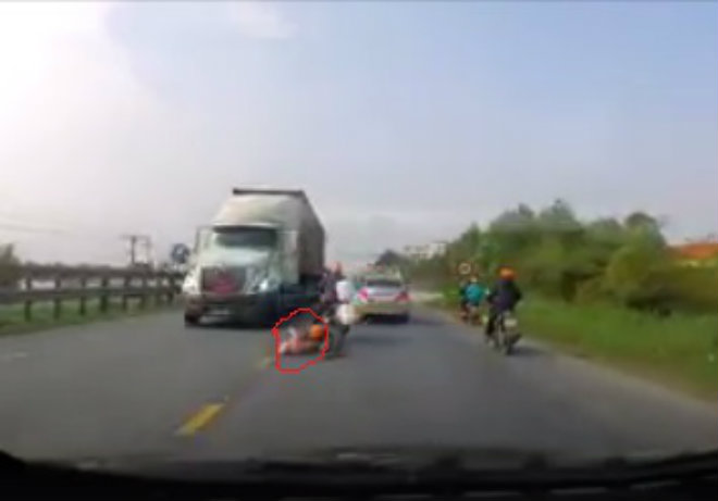 Video: Thót tim 2 mẹ con ngã xe máy lăn ngay gầm xe tải - 1