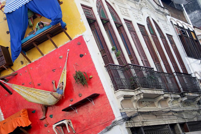 11, “Nhà” của nghệ sĩ người Brazil Brazil Tiago Primo và anh trai ông chỉ là những tấm võng, bạt, được đóng trực tiếp lên tường của một ngôi nhà khác.