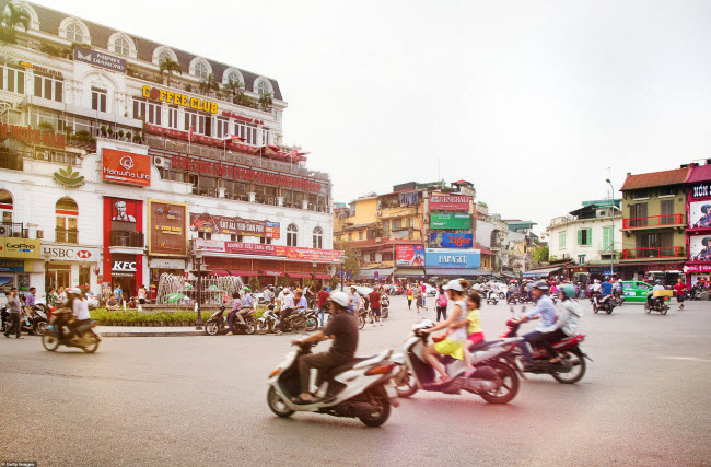Mọi người di chuyển bằng mô tô trên đường phố ở Hà Nội.