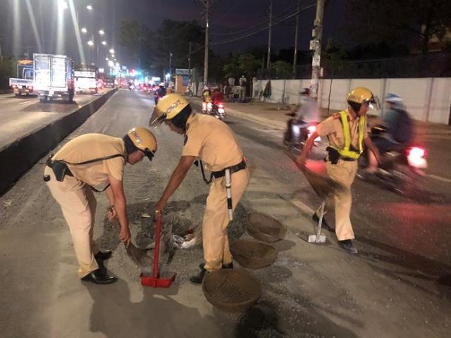 Tin tức trong ngày - CSGT mang rổ rá, thùng xốp hốt đá sỏi cho dân khỏi trượt té