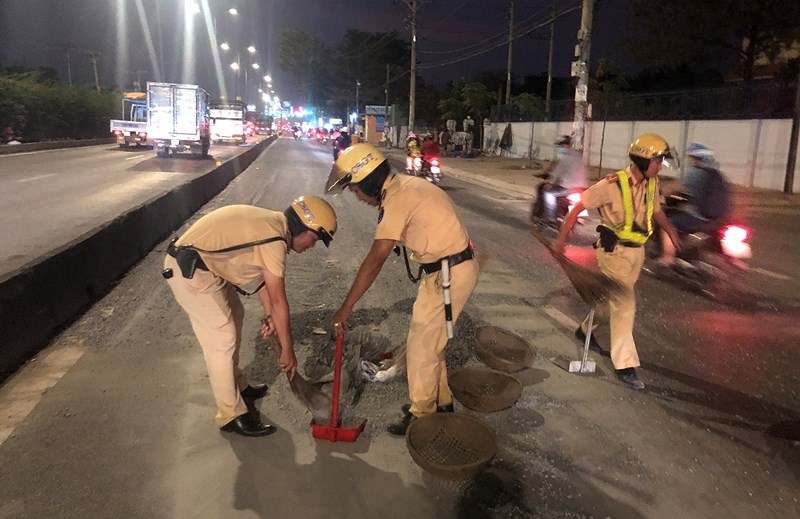 CSGT mang rổ rá, thùng xốp hốt đá sỏi cho dân khỏi trượt té - 1