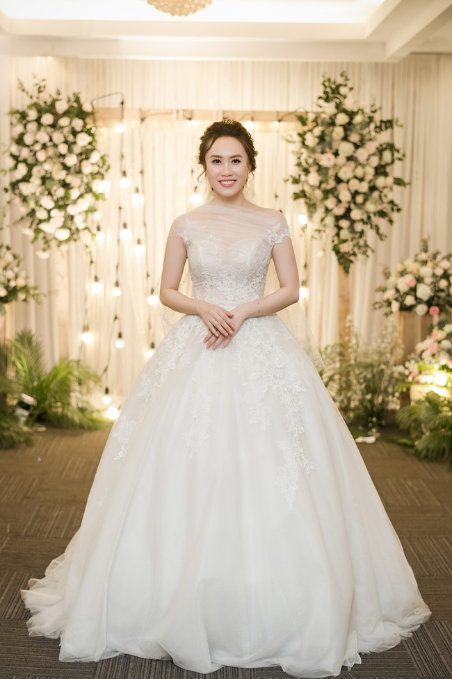 Cô dâu Thu Hà diện váy cưới của NTK Lek Chi. Đây là mẫu đầm bồng công chúa có kèm tùng váy, màu ánh kim vàng được thêu 3D từ chỉ tơ vàng.