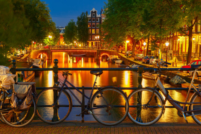 Amsterdam, Hà Lan: Thành phố của những dòng kênh trở nên lung linh khi màn đêm buông xuống. Du khách có thể chiêm ngưỡng các cây cầu vòm được chiếu sáng rực rỡ hay hòa mình vào không khí náo nhiệt tại khu Leidseplein.