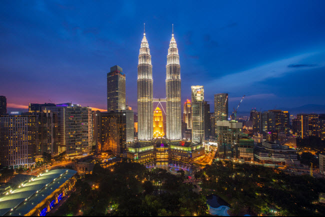 Kuala Lumpur, Malaysia: Tháp đôi Petronas, tháp Menara và khu chợ đêm Petaling được chiếu sáng rực rỡ khi màn đêm buông xuống. Du khách ra ngoài vào buổi tối ở Kuala Lumpur có thể đến một số quán hát karaoke.