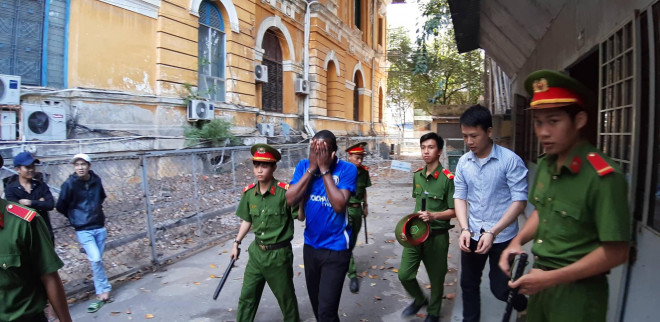 Bị cáo Chime Obiora Walter liên tục che mặt sau khi ra khỏi phòng xử án