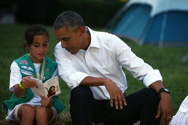 Một bé gái nói với ông Obama về quyển sách đang đọc trong buổi đốt lửa trại tại Nhà Trắng vào tháng 6/2015. Ảnh: Getty Images.