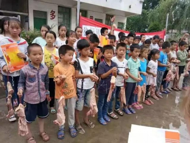 Học sinh Trung Quốc nhận thưởng thịt lợn.