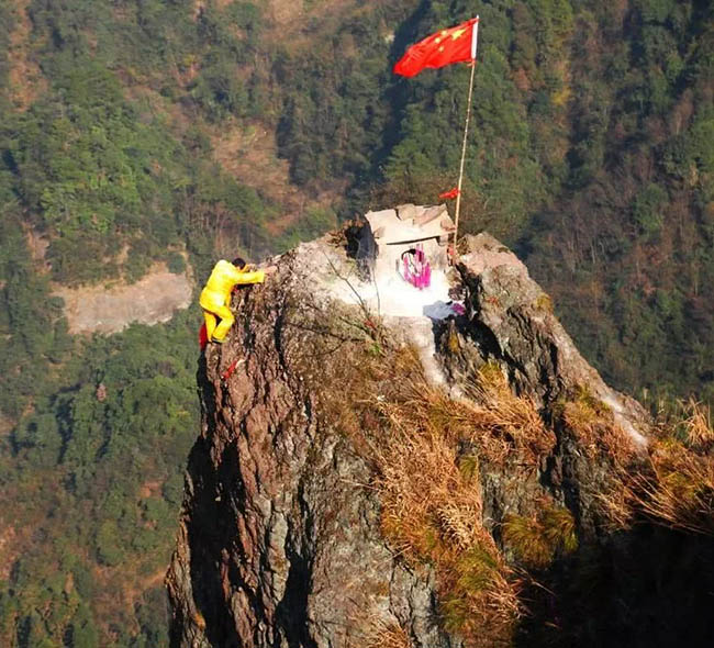 1. Ngôi đền thờ bé xíu này nằm ở độ cao đến vài trăm mét, cách đỉnh cao nhất là 50 mét tại một khu vực nhiều đồi núi Quảng Tây. Bất chấp địa hình hiểm trở, người dân vẫn trèo lên đây bằng dây.
