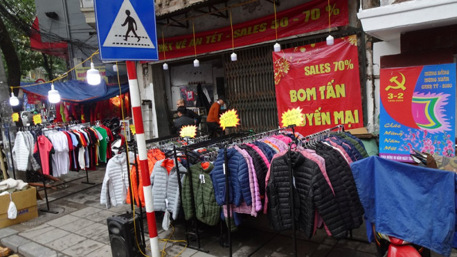 Ngay từ sáng sớm ngày 28 Tết, nhiều cửa hàng thời trang trên phố Hàng Bông, Hàng Ngang bày bán kín hàng trên vỉa hè với những bảng hiệu giảm giá khủng.