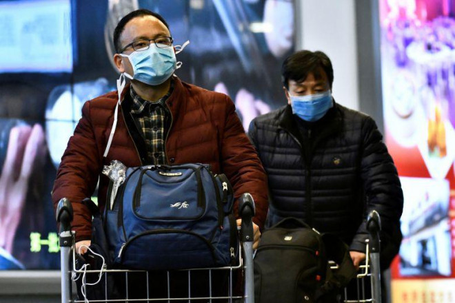 Hành khách đeo khẩu trang tại sân bay quốc tế Vancouver sau khi đáp từ Trung Quốc hôm 24-1. Ảnh: Reuters