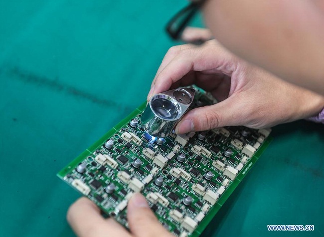 Thậm chí, trong làng còn có nhà máy công nghệ cao. Hình ảnh chụp một công nhân đang kiểm tra chip tại nhà máy.