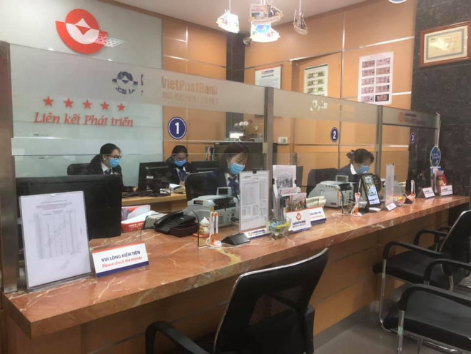 Các giao dịch viên tại ngân hàng LienVietPostBank đeo khẩu trang phòng ngừa dịch nCov.