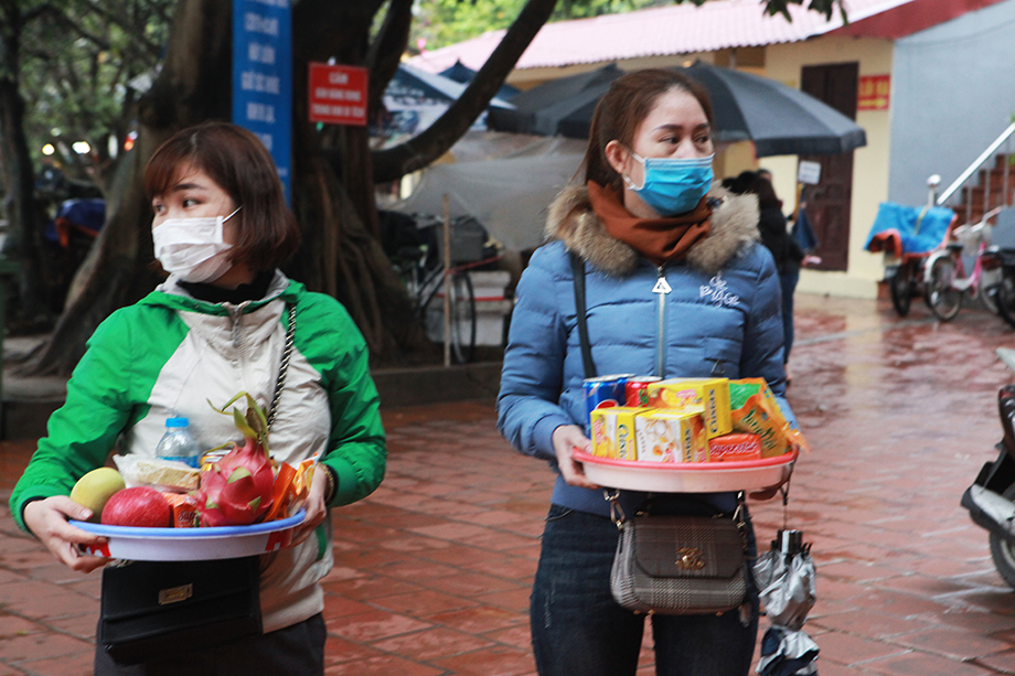 Người dân bịt kín khẩu trang, bê lễ vào khuôn viên phủ Tây Hồ mà không phải chen lấn như mọi khi - thời điểm chưa có dịch virus Corona.