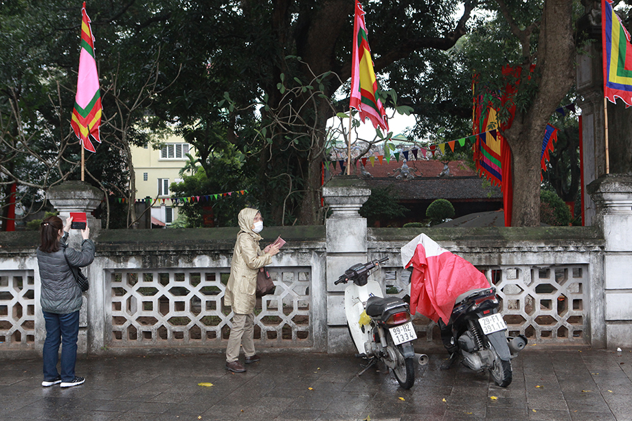 Không được vào bên trong, du khách người nước ngoài chụp ảnh qua bức tường rào.