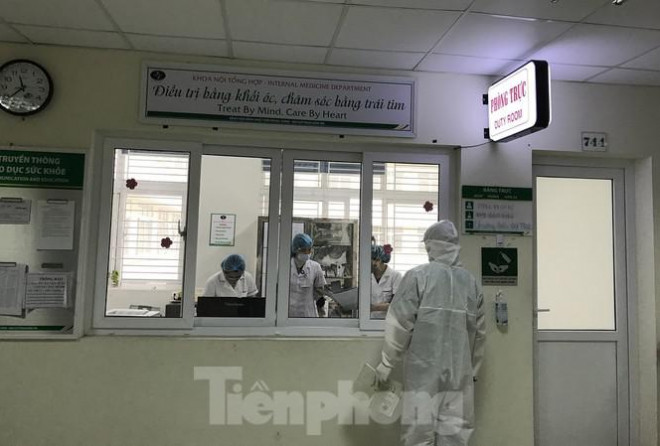 Bàn giao bệnh nhân nghi nhiễm virus Corona mới cho khu vực cách ly đặc biệt trên tầng 7. Ảnh: Thái Hà