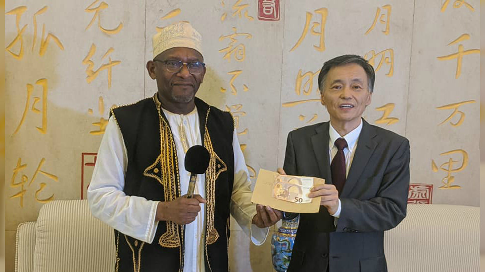 Ông Ahamada Msa M&#39;liva trao tiền hỗ trợ cho Trung Quốc (ảnh: RT)