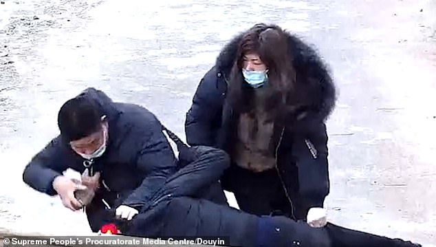 Xie (trái) cầm gạch đánh vào đầu nhân viên chống dịch Corona trong khi Shao hùa theo chồng. Ảnh: Trung tâm Media viện kiểm sát nhân dân tối cao TQ