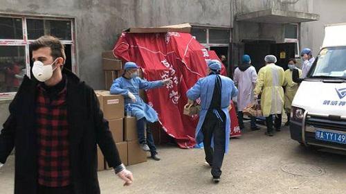 Hina Kalami (áo đen bên trái) hỗ trợ các nhân viên y tế trên một con đường tại Vũ Hán. Ảnh: Thời báo Hoàn Cầu