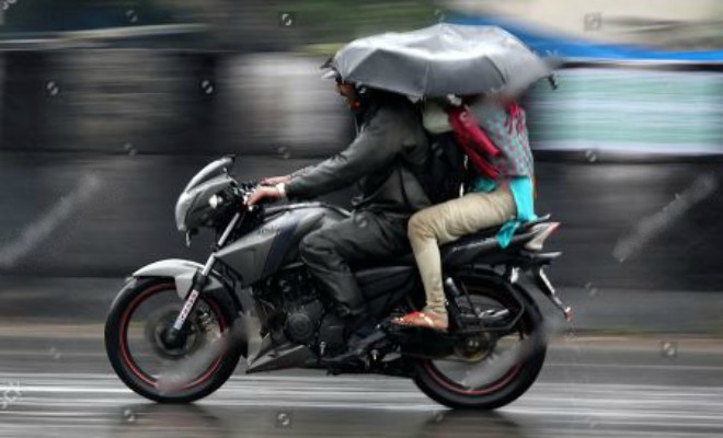 Sử dụng ô khi di chuyển bằng xe máy là vi phạm quy tắc giao thông đường bộ.