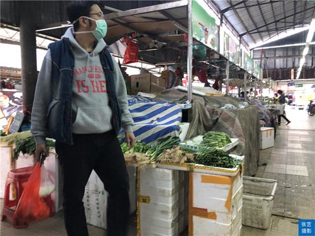 Khách hàng đi mua đồ ăn ở một khu chợ ở Quảng Châu. Khách vào chợ sẽ được đo nhiệt độ để xem có ai bị sốt hay không.