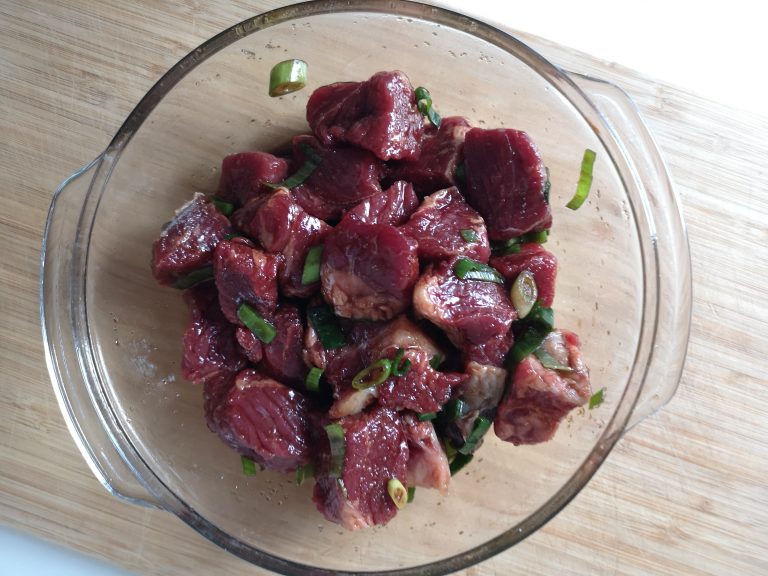 Cắt miếng thịt bò thành khối vuông vừa ăn, sau đó trộn với các nguyên liệu chuẩn bị sẵn để ướp bò bít tết rồi để trong tủ lạnh 1 tiếng.