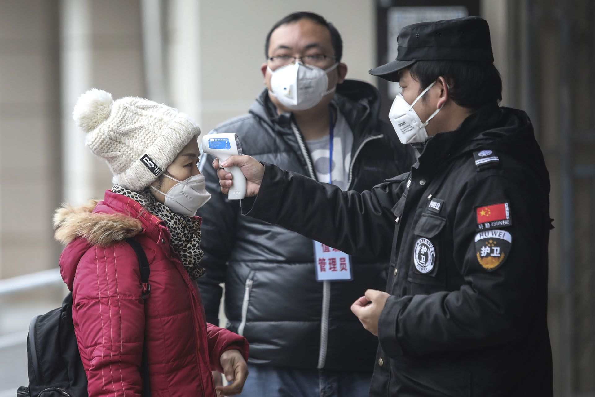 Nhân viên y tế đo thân nhiệt cho người đi đường tại Vũ Hán (ảnh: SCMP)