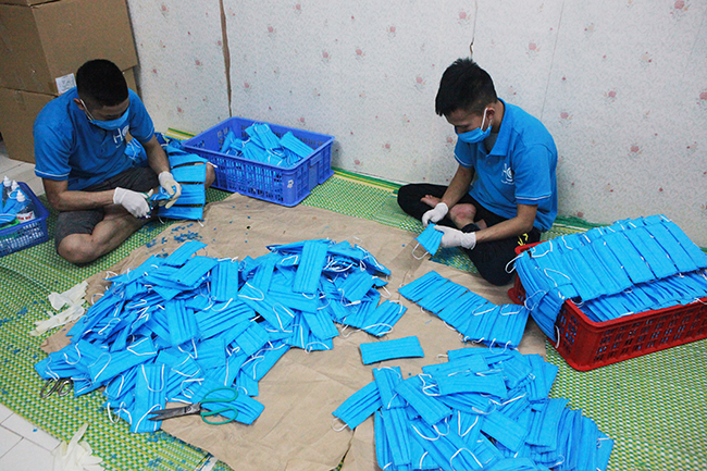 Ngoài Hội phụ nữ xã Hải Bối đến giúp, các công nhân nam trong xưởng thực hiện công đoạn nhặt chỉ, xịt cồn khử trùng và đóng gói khẩu trang