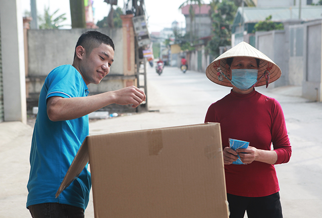 Khẩu trang sau khi hoàn thành được xếp đầy trong những chiếc thùng đặt trước cửa xưởng của chị Thắm