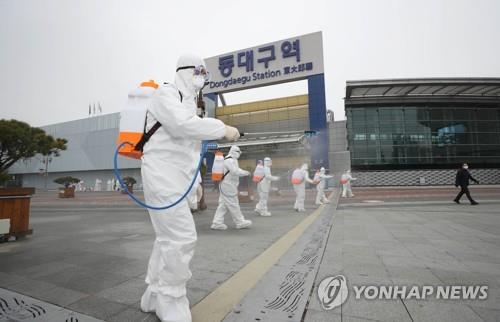 Các nhân viên y tế phun thuốc khử trùng ở thành phố Daegu.