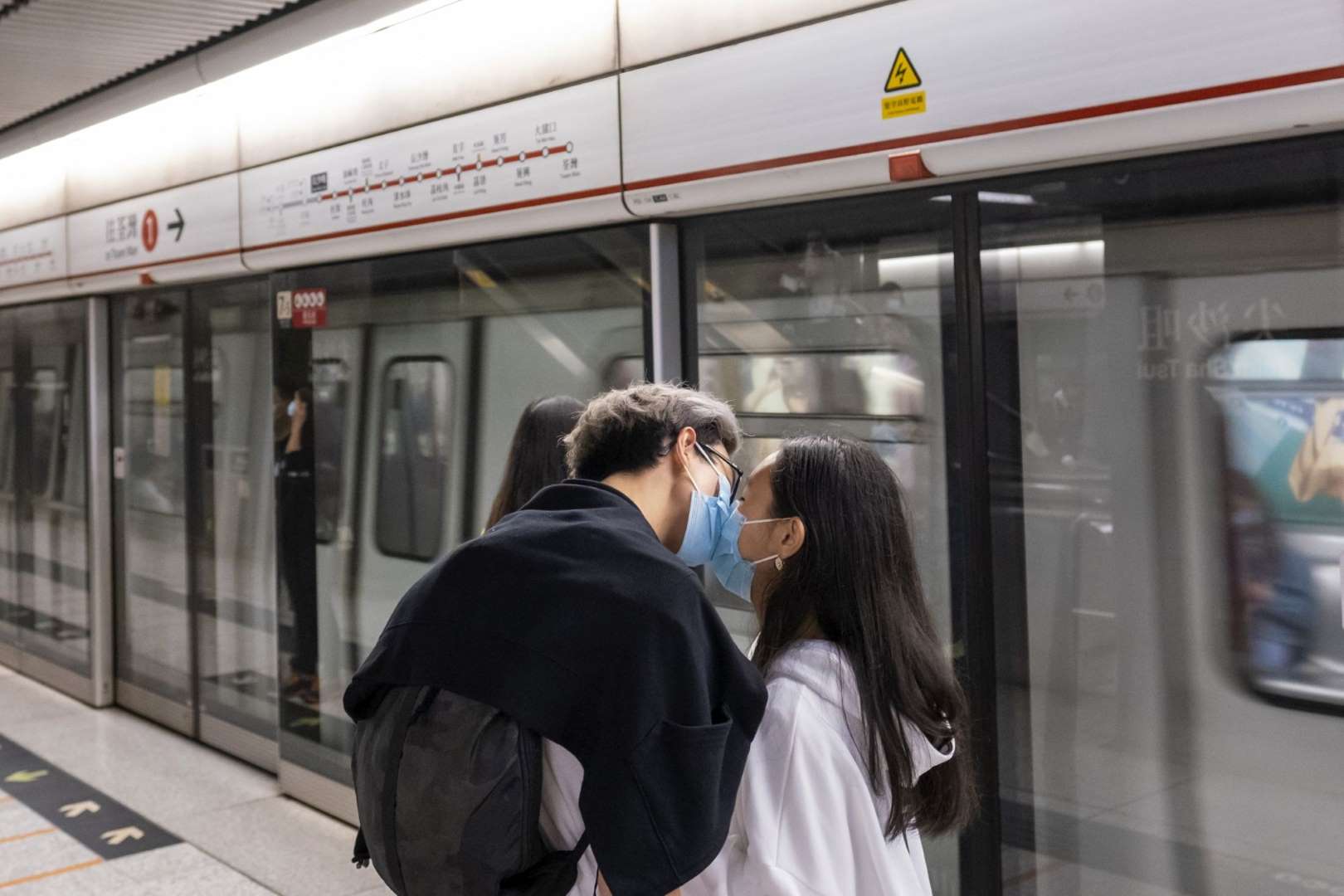 Cặp đôi tranh thủ "khóa môi"&nbsp;dù vẫn đeo khẩu trang y tế tại một&nbsp;ga tàu điện ngầm ở Hong Kong (Ảnh: Bloomberg)