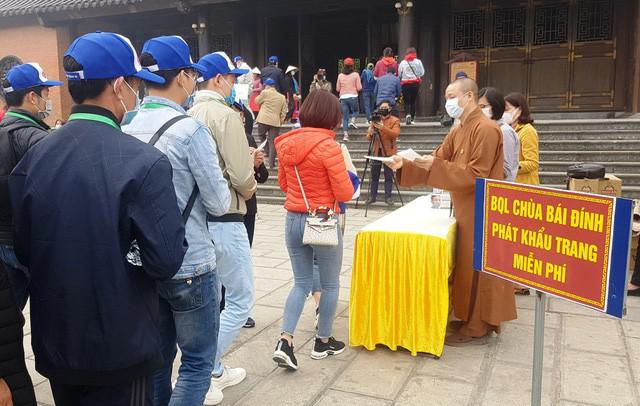 Phát khẩu trang miễn phí cho du khách tại chùa Bái Đính - Ảnh: DT