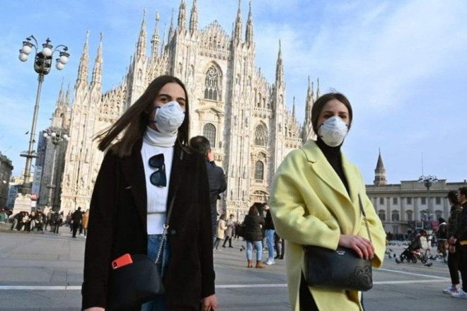 Người dân đeo khẩu trang phòng chống COVID-19 ở quảng trường Piazza del Duomo, Milan, ngày 23-2-2020 - Ảnh: AFP