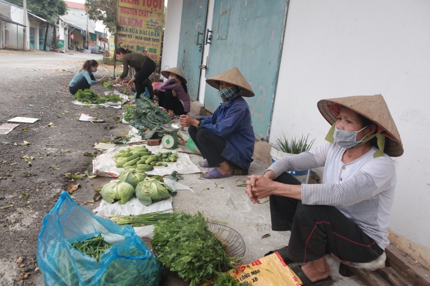 &nbsp; Một vài người phụ nữ ngồi bán rau ở đầu làng trong phiên chợ chiều.