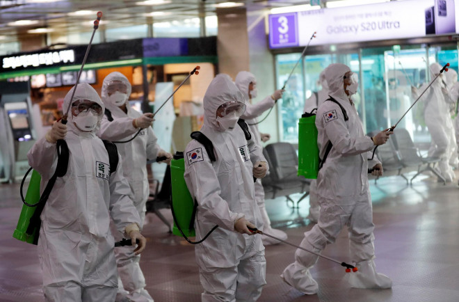 Binh sĩ phun thuốc khử trùng tại một sân bay ở TP Daegu - Hàn Quốc ngày 6-3 Ảnh: REUTERS