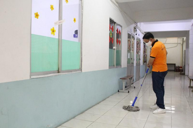 Giáo viên trường THCS - THPT Đào Duy Anh tổng vệ sinh phòng học để chuẩn bị đón học sinh lớp 12 đi học trở lại. Ảnh: MINH TRẦN