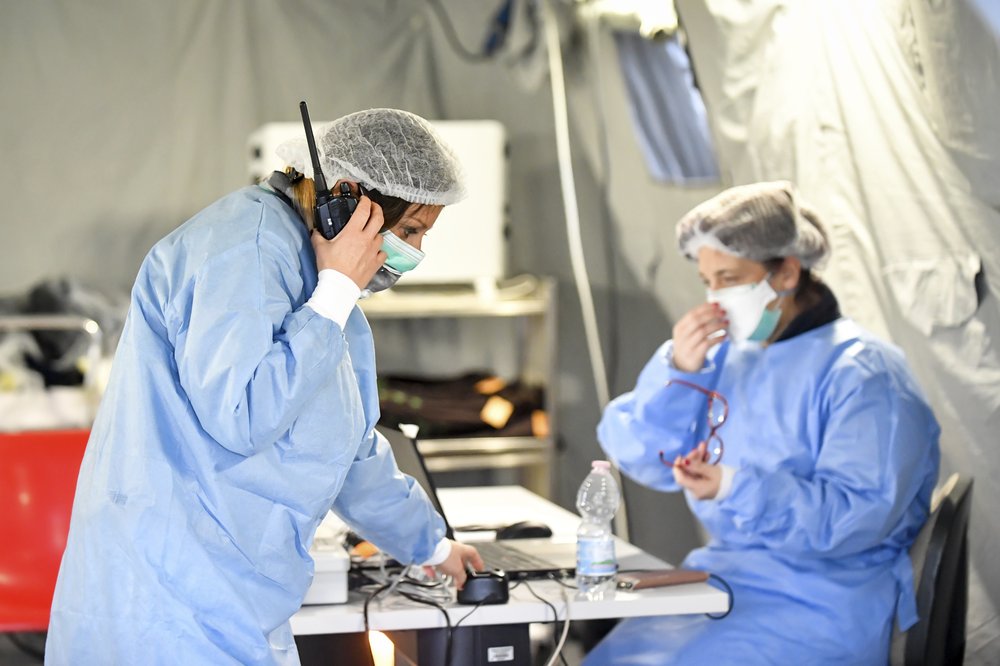 Nhân viên y tế làm việc trong chiếc lều được dựng trong khuôn viên một bệnh viện tại Italia (ảnh: AP)