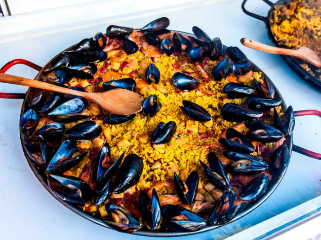 1. Paella, Tây Ban Nha: Đây là món truyền thống của Tây Ban Nha có nguồn gốc từ vùng Valencia. Nó bao gồm cơm, hải sản và rau được bày trong một chiếc đĩa lớn.