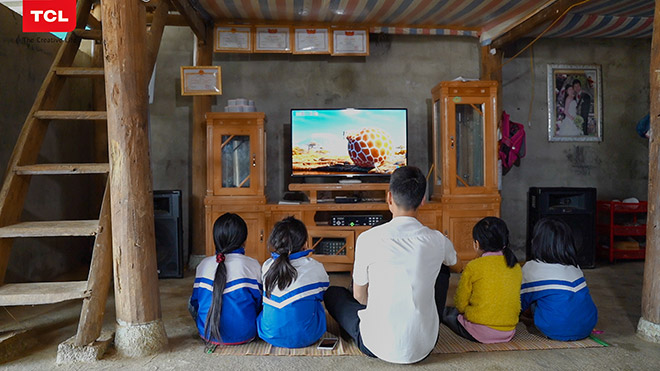 Anh Quang cùng các cháu học sinh trong làng đang thích thú ngồi xem tivi.